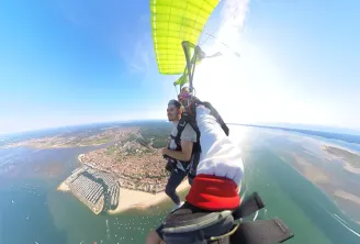 Skydiver in freefall above Bordeaux city with aerial view of urban development, tidal basins and Gironde estuary