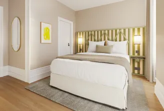 Elegant bedroom at Clos Huguerie in Bordeaux featuring a white bed with green and beige striped headboard, gold oval mirror, light beige walls, wooden flooring, and minimalist décor accents.