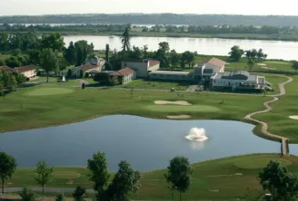 Aerial view of Le Relais de Margaux Hotel in Bordeaux featuring buildings, a pond, manicured lawns, and the Garonne River in the background