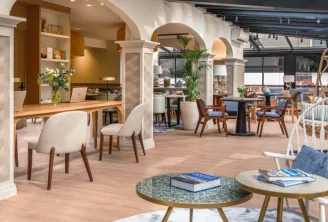 Elegant lobby of Arcanse by Inwood hotel in Bordeaux featuring reception areas, modern seating with wooden and blue furnishings, large windows, and contemporary décor