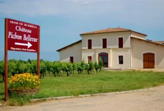 Entrance sign of Château Pichon Bellevue with the main building in the background, located in Bordeaux vineyards