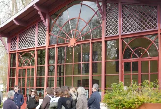 Front facade of the Georges de Sonneville Museum in Bordeaux featuring large paned windows and a glass roof in Art Nouveau style, with visitors gathered at the entrance