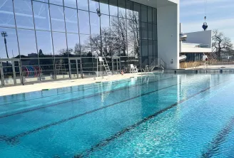 Interior view of the Olympic swimming pool at UCPA Aqua Stadium in Mérignac, Bordeaux, featuring well-marked lanes and a modern glass facade