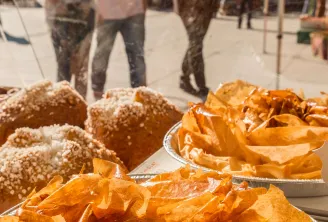 Display of fresh bread and pastries at Pey Berland market in Bordeaux, featuring sugar-dusted brioche and golden croissants on serving trays.