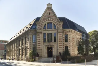 Facade of the Hôtel La Zoologie in Bordeaux, a historic stone building with mansard roof, large arched windows, and architectural details in red brick and light stone.