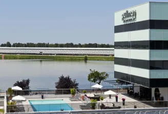 Pullman Bordeaux Lac hotel featuring striped modern architecture overlooking a water basin with outdoor swimming pool and terrace