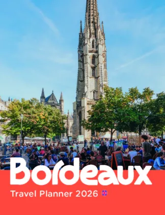 Bordeaux's Saint-Michael Basilica with its prominent Gothic spire towering over a lively square filled with visitors under a clear blue sky, with 'Bordeaux Travel Planner 2026' text overlay.