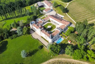 Aerial view of Château Toulouse Lautrec near Bordeaux, displaying the white château with inner courtyard, swimming pool, vineyards and surrounding farm buildings