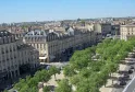Aerial view of Allées de Tourny in Bordeaux featuring Haussmann-style buildings, green trees, and stone facades.