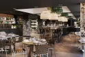Modern restaurant interior featuring a central wooden bar, round and high dining tables, designer chairs, natural rattan pendant lights, decorative patterned columns, wall shelving, contemporary ceiling with skylight and greenery, at Bordeaux's Les Décant