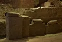 Archaeological remains from the Saint-Seurin site in Bordeaux: ancient pottery and ceramic fragments displayed on stone blocks in an underground excavation.