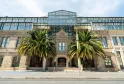 Front façade of Mercure Bordeaux Château Chartrons hotel in Bordeaux, featuring a historic stone building with modern glass roof structure and two palm trees