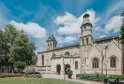 Basilica of Saint-Seurin in Bordeaux, a white stone religious building with two towers, surrounded by greenery and a landscaped square under a clear blue sky.