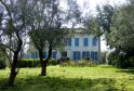 Beau Rivage Estate near Bordeaux, white stone mansion with blue shutters surrounded by olive trees and manicured gardens