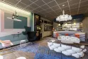 Modern lobby of Ibis Styles Bordeaux Meriadeck hotel featuring a bar counter, contemporary seating area with white and orange furniture, geometric ceiling design, and stylish interior décor
