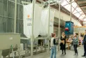 Guided tour of the Bestmalz brewery in Bordeaux with visitors observing fermentation tanks and brewing equipment in an industrial warehouse.