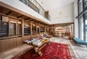 Elegant interior of Château Fleur de Lisse in Bordeaux, featuring wooden wine storage racks filled with bottles, a tasting counter, and refined interior design with white walls and exposed beams.