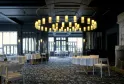 Elegant dining room at La Grand'Vigne in Bordeaux featuring round tables with white linens, modern brass chandelier, floor-to-ceiling windows, and contemporary minimalist decor.