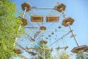 Aerial adventure park with wooden platforms and rope courses suspended between trees at Cimes de Bordeaux in Pessac.