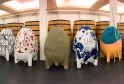 Collection of decorated oak barrels of various sizes and artistic designs arranged in a winemaking cellar at Château Larrivet Haut-Brion in Bordeaux.
