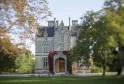 Château Lanessan in Bordeaux, a grand stone mansion with turrets and slate roof, surrounded by autumn foliage and red ivy.