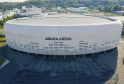 Aerial view of Arkea Arena, a modern white and grey rounded arena located in Floirac near Bordeaux, with parking areas and access plaza in the foreground.