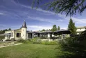 L'Atelier de Candale in Bordeaux, a modern architectural building featuring a conical tower, surrounded by lush gardens and shaded terraces.