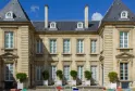 Facade of the Museum of Decorative Arts and Design in Bordeaux, a classical stone building with mansard roofs, mullioned windows and a garden with topiary box shrubs