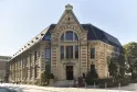 Facade of the Hôtel La Zoologie in Bordeaux, a historic stone building with mansard roof, large arched windows, and architectural details in red brick and light stone.